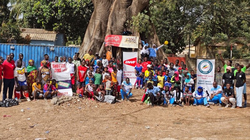 Large group of people standing in front of a tree. 