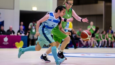 Two Special Olympics basketball players in action as they struggle to control the ball