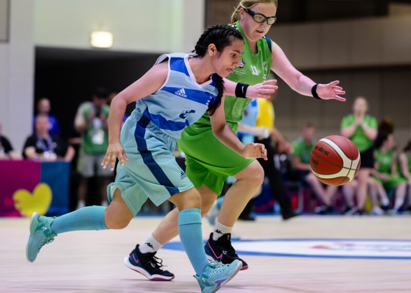 Two Special Olympics basketball players in action as they struggle to control the ball