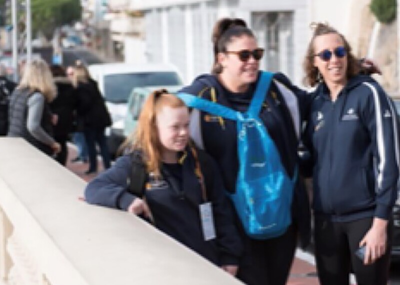 Nicole Harris on the far right standing with two other young teammates. 