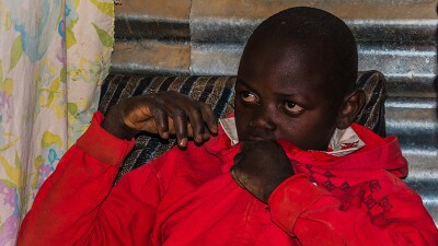 Zadock Mavinda, a 16-year old, sits in his house during the Golisano Foundation's visit.