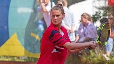 Young woman holding a racket on the court preparing to swing. 