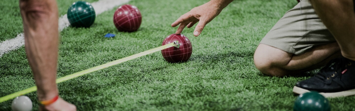 Official on the field measure the distance between two balls as a player observes.