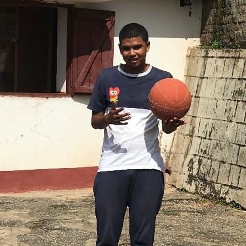 Sammy standing outside with a basketball in hand. 