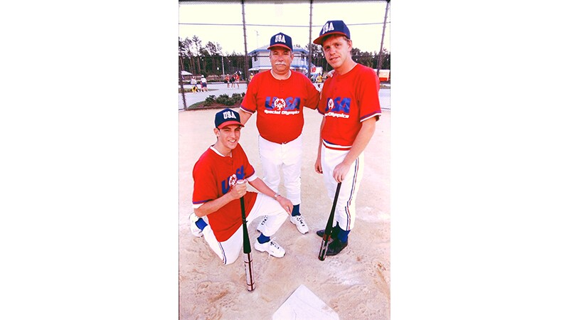 Three men from the USA Softball team poses for a photo.