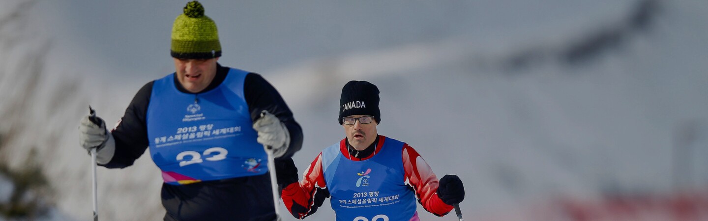 Two male athlete cross country skiers skiing. 