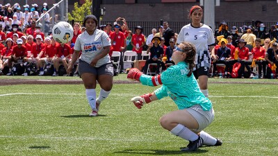 Young female keeper catching the football. 