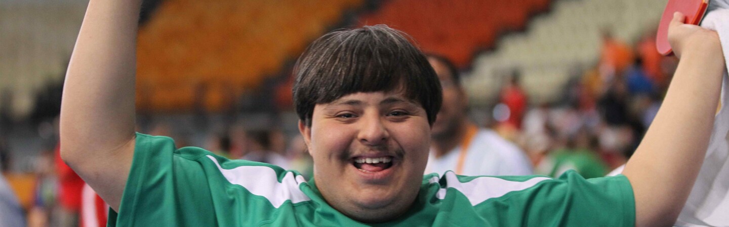 Young male athlete cheering with a paddle in his hand. 