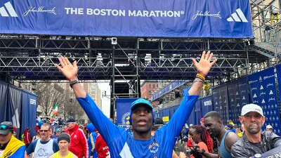 Trent Hampton with arms up in the victory pose above his head after crossing the finish line 