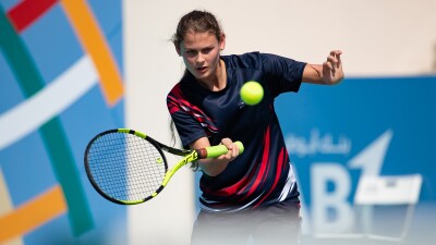 Lily Mills swings a net with the ball in mid-air.