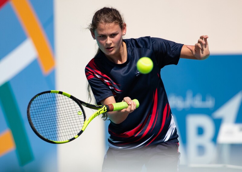 Lily Mills swings a net with the ball in mid-air.