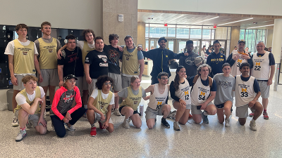 Two Unified basketball teams pose for a group photo. Members are wearing uniforms and smiling for the photo. 