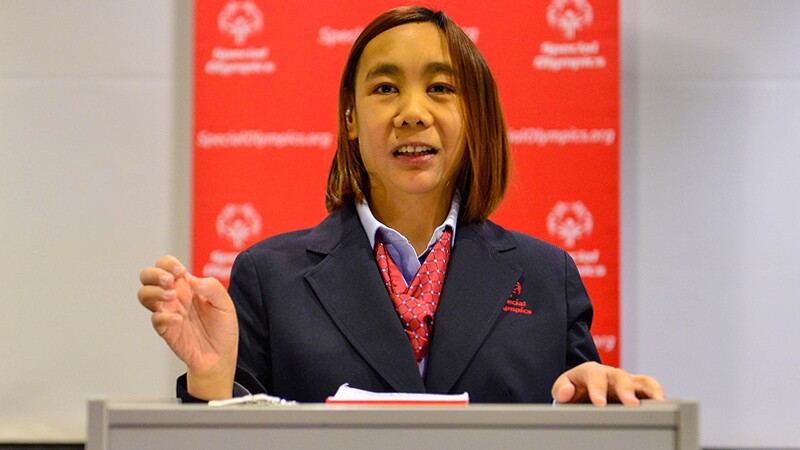 Woman standing behind a podium giving a speech. 