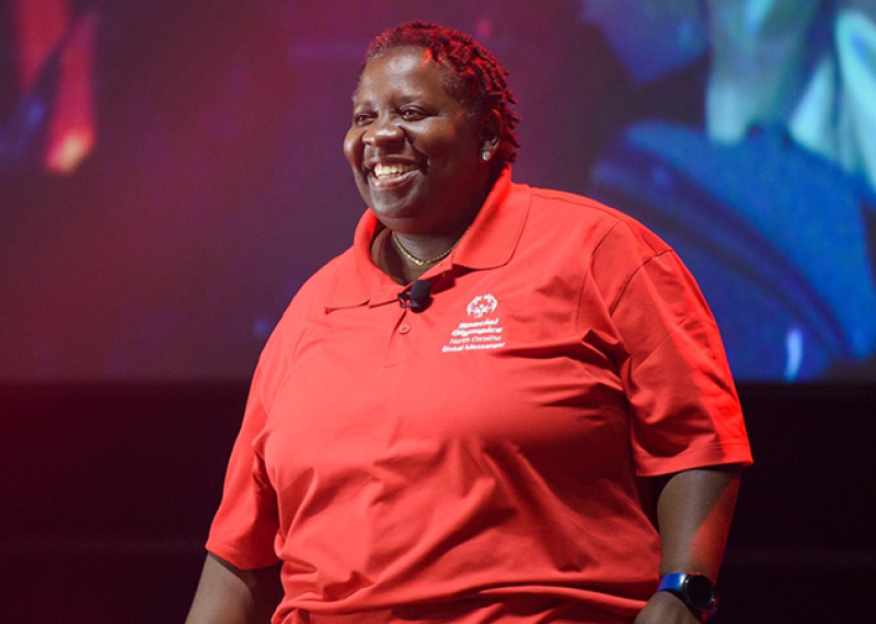 A Special Olympics athlete stands on a stage. 