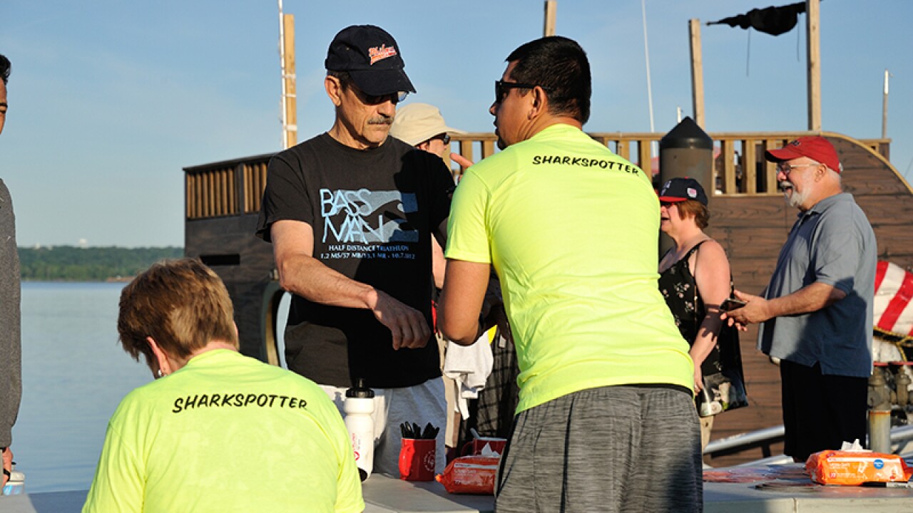 Two volunteers (one sitting and one standing) registering attendees. 