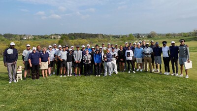 A large group of golfers pose together.