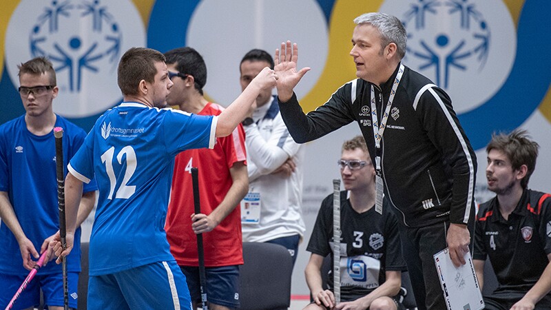 Athlete in jersey no. 12 gives Urban Karlsson a high-5 during a game. 