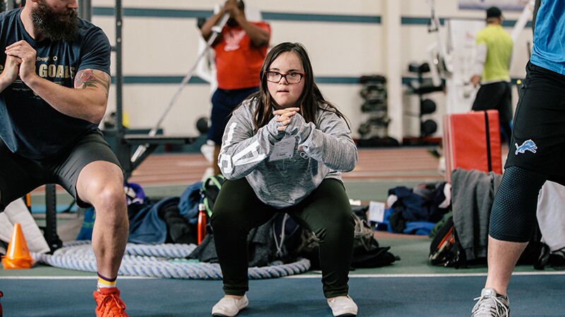 Athletes performing squats in a gym. 