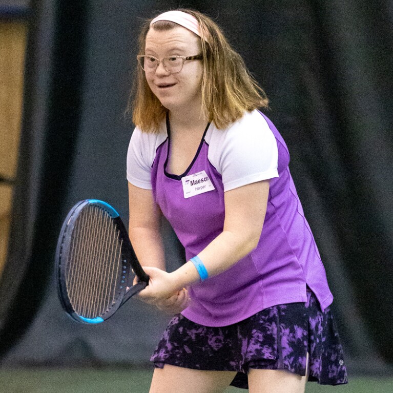 Female athlete holding the racket readying for a hit. 