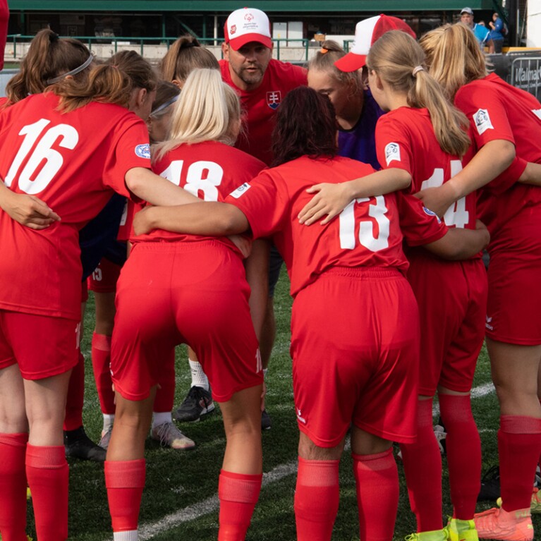 Female footballers in a huddle. 