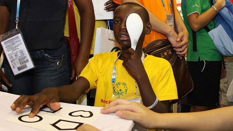 Young man covering up one eye for an eye exam. 