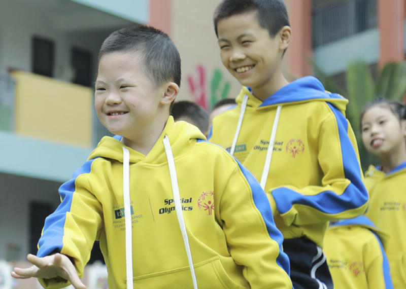 Young children walking in a single file line. 