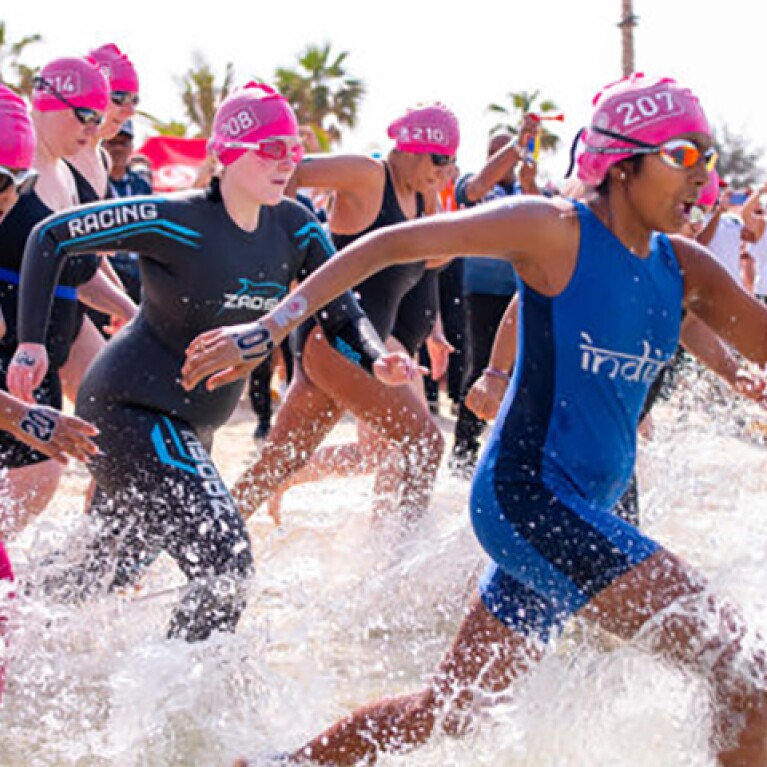 Athletes running into the water for an Open Water Swimming event. 