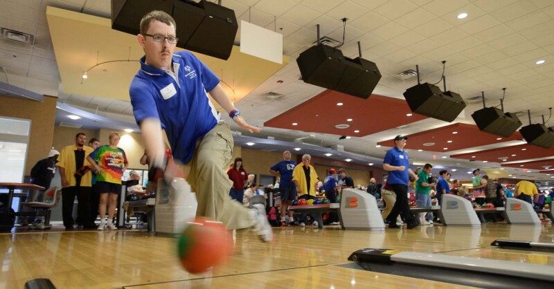 Male athlete in a blue polo releases the ball. 