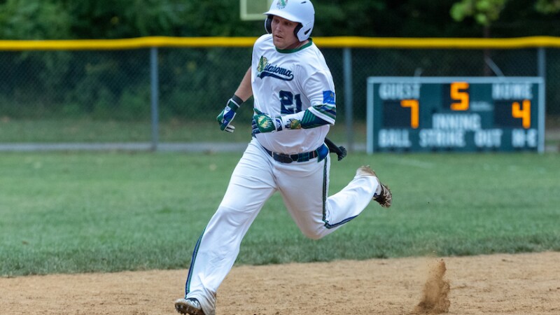 A softball athlete runs around the bases during a game. 