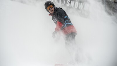 Snow rises up around Cody Field as he comes to a stop while snowboarding.